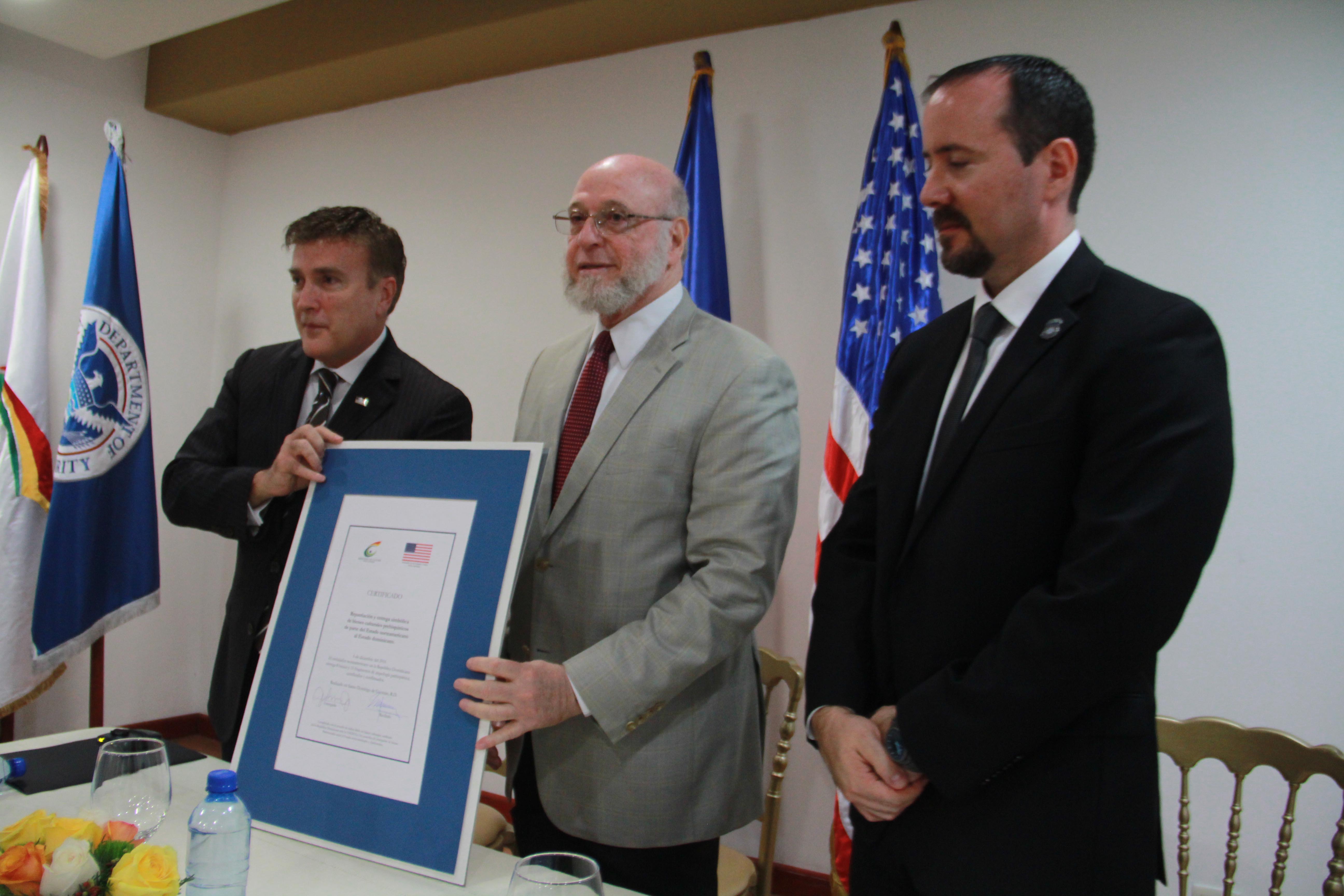 El ministro Vergés y el embajador James W. Brewster muestran el documento firmado durante el acto.