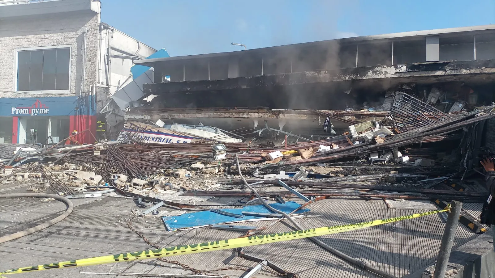 Incendio aún persiste en escombros de edificio colapsado en la 27 de Febrero