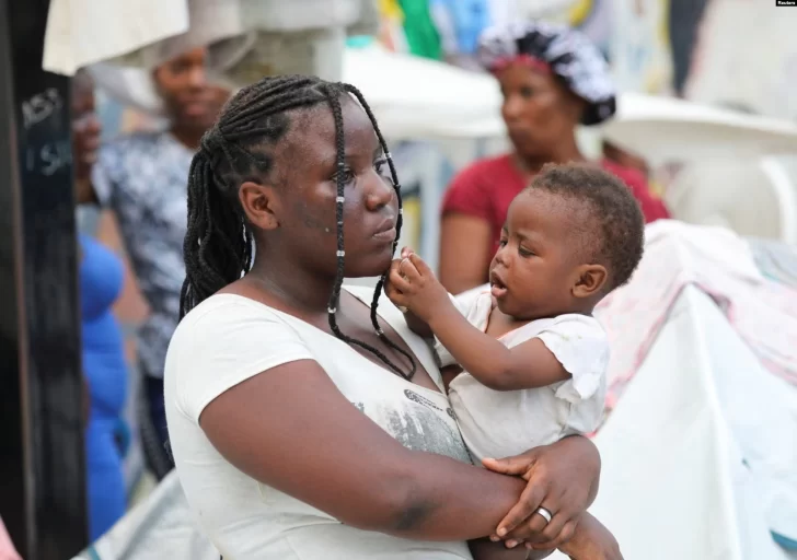 Una-mujer-sostiene-a-un-bebe-en-un-estadio-deportivo-donde-se-han-refugiado-de-la-violencia-en-Puerto-Principe-728x512