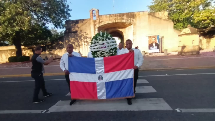 Cruzando la ofrenda de floral del altar de la patria a la estatua de Francisco Alberto Caamaño. 