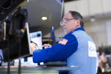 Wall Street cierra verde con tipos inamovibles y riesgos por aranceles