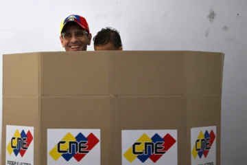  El líder opositor y candidato a diputado venezolano, Henrique Capriles Radonski, vota con su hijo en brazos en un colegio electoral durante las elecciones regionales de Caracas el 25 de mayo de 2025. La baja participación electoral se registró el domingo en las elecciones a gobernador y parlamentarias de Venezuela, después de que la mayoría opositora llamara a la abstención en protesta por la controvertida reelección del presidente Nicolás Maduro. (Foto: Federico PARRA / AFP)