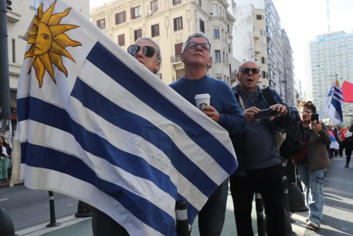  AME7435. MONTEVIDEO (URUGUAY), 14/05/2025.- Una mujer sostiene una bandera de Uruguay durante el cortejo fúnebre del expresidente uruguayo José Mujica este miércoles, en Montevideo (Uruguay). Mujica falleció este martes en Montevideo a los 89 años, un año después de que le descubrieran un tumor maligno en el esófago. EFE/ Alejandro Prieto