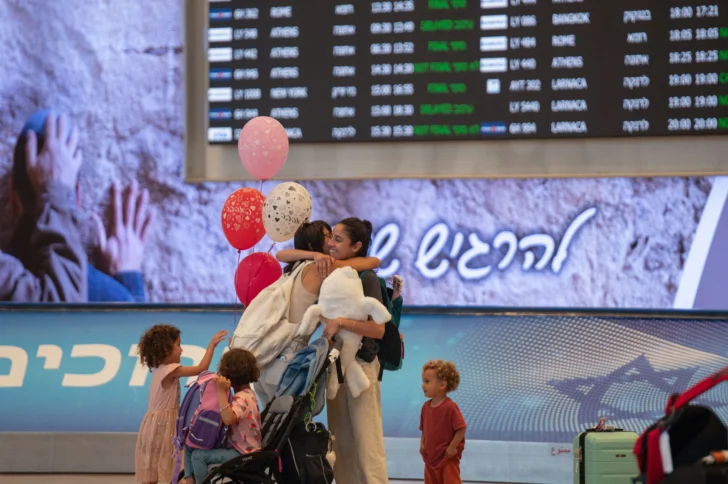  TEL AVIV (ISRAEL), 25/06/2025.- Varias personas en el interior de la terminal del aeropuerto Ben Gurión de Tel Aviv este miércoles. Con globos de colores, banderas israelíes y carteles de bienvenida, familias esperan la sala de llegadas del aeropuerto Ben Gurión, que hoy retoma su ritmo habitual por primera vez desde que comenzó la escalada bélica con Irán el 13 de junio. EFE/ Magda Gibelli
