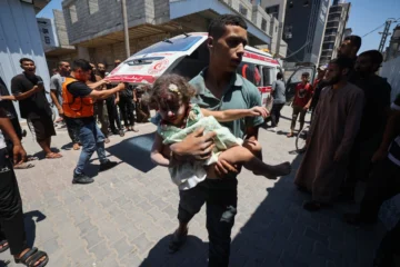  Un joven palestino lleva a una niña herida en un ataque israelí en el centro de la Franja de Gaza, el 19 de julio de 2025. (Foto de Eyad BABA / AFP)