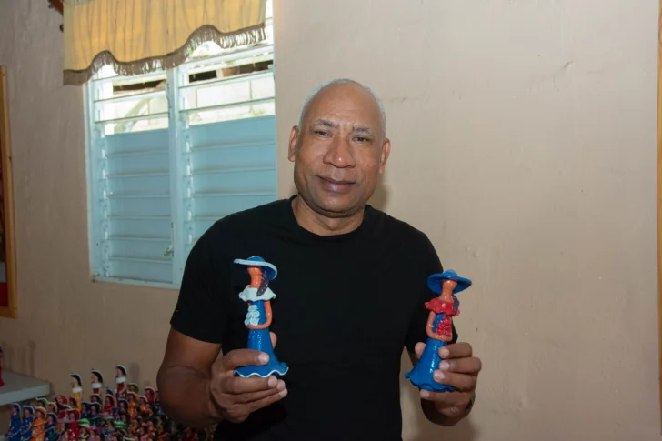  Artesano Luis Rodríguez con dos modelos de sus muñecas de estilo tradicional. Foto: ©️ Juan Antonio Guio. ACENTO