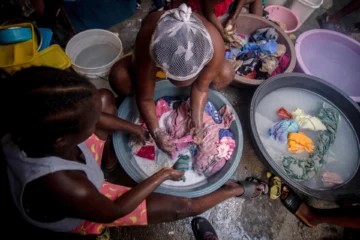  PUERTO PRÍNCIPE (HAITÍ), 19/08/2025.- Fotografía del 14 de agosto de 2025 de mujeres lavando ropa en el interior de una carpa en el campamento de refugiados OPC, en Puerto Príncipe (Haití). 