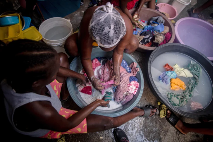 PUERTO PRÍNCIPE (HAITÍ), 19/08/2025.- Fotografía del 14 de agosto de 2025 de mujeres lavando ropa en el interior de una carpa en el campamento de refugiados OPC, en Puerto Príncipe (Haití). 
