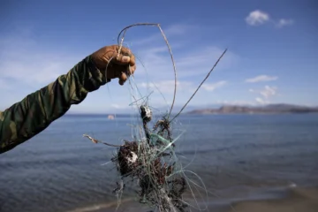  AME1037. LAS SALINAS DE BANÍ (REPÚBLICA DOMINICANA), 20/09/2025.- Una persona muestra desechos en una playa este jueves, en Las Salinas de Baní (República Dominicana). Voluntarios y pescadores se han unido para retirar desechos de pesca, como redes e hilos de nailon, que amenazan la vida de los flamencos y otras aves en la playa Las Salinas (sureste de la República Dominicana), en una de las tantas actividades convocadas en el país con motivo de la celebración este sábado del Día Internacional de Limpieza de Costas. EFE/Orlando Barría