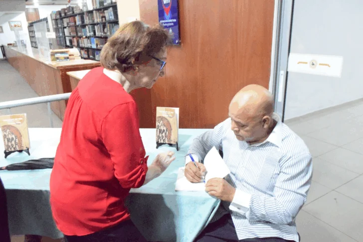  Enegildo Peña firma un libro a la poeta Carmen Comprés.
