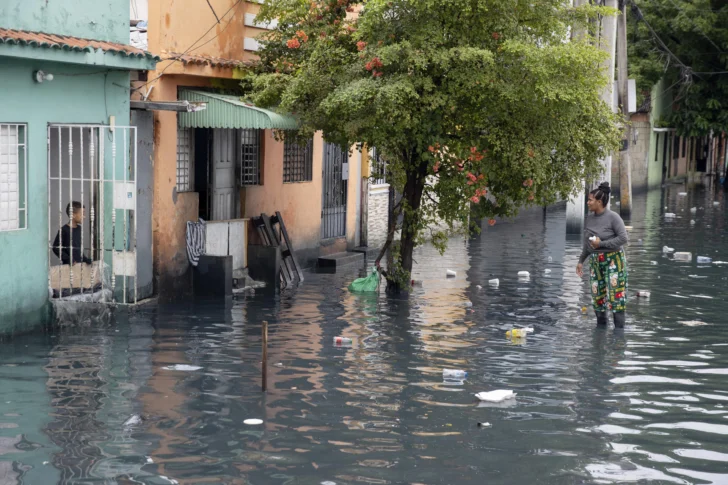  AME863. SANTO DOMINGO (REPÚBLICA DOMINICANA), 23/10/2025.- Una mujer camina por una calle inundada este jueves, en Santo Domingo (República Dominicana). Más de 647.000 usuarios están sin agua potable en República Dominicana después de que las lluvias provocadas por la tormenta tropical Melissa afectaran decenas de acueductos. EFE/ Orlando Barría.