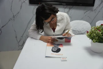  Yinett Santelises firmando un ejemplar de El vuelo de Sina.