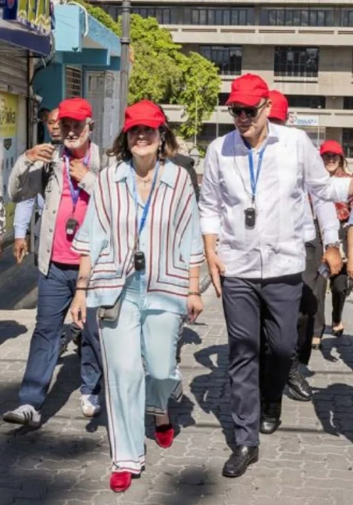  María Amalia León, acompañada del alcalde Ulises Rodríguez y Danilo Ginebra, aprecia la exposición mientras recorre la calle Benito Monción. (Fuente externa).
