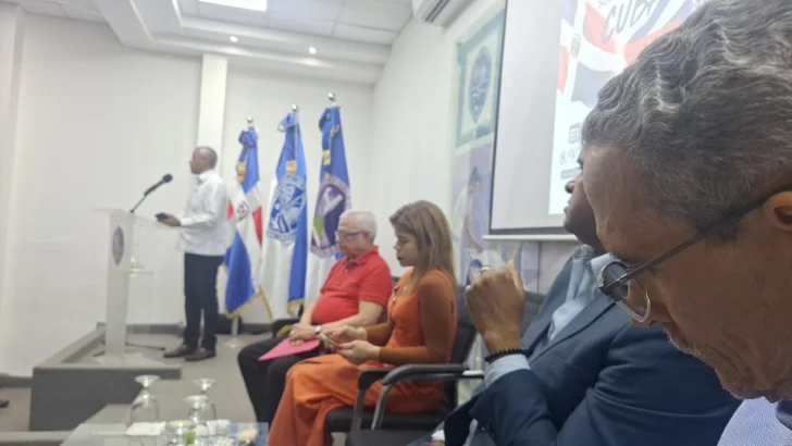 Momento en que el excelentísimo Embajador de la República de Cuba en el país, Ángel Arzuaga Reyes, hace uso de la palabra e inaugura el recital lírico-poético en solidaridad con Cuba, en el Paraninfo de Humanidades-UASD. Sentados en la mesa de coordinación: el cantautor dominicano Luis Tomás Oviedo; la Dra. Ibeth Guzmán, Directora de la Escuela de Letras y representante de la señora Decana de la Facultad de Humanidades-UASD, Dra. Ana Jacqueline Ureña (quien se excusó); y los coordinadores del evento cultural Víctor Saldaña, Ramón Tejeda Read y Julio Cuevas (este último oculto en la foto).