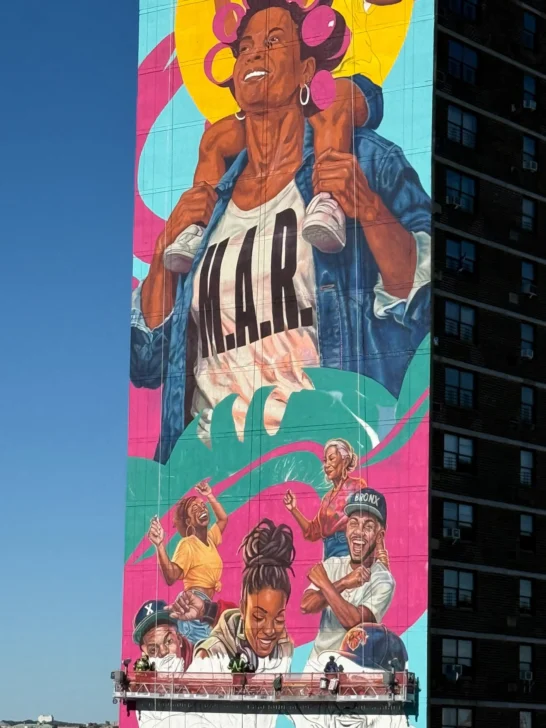 Angurria pinta mural más alto de EEUU: mujer en rolos a 29 pisos de altura
